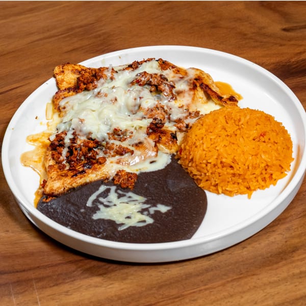 Grilled chicken topped with melted cheese, seasoned meat, orange rice, and refried beans.